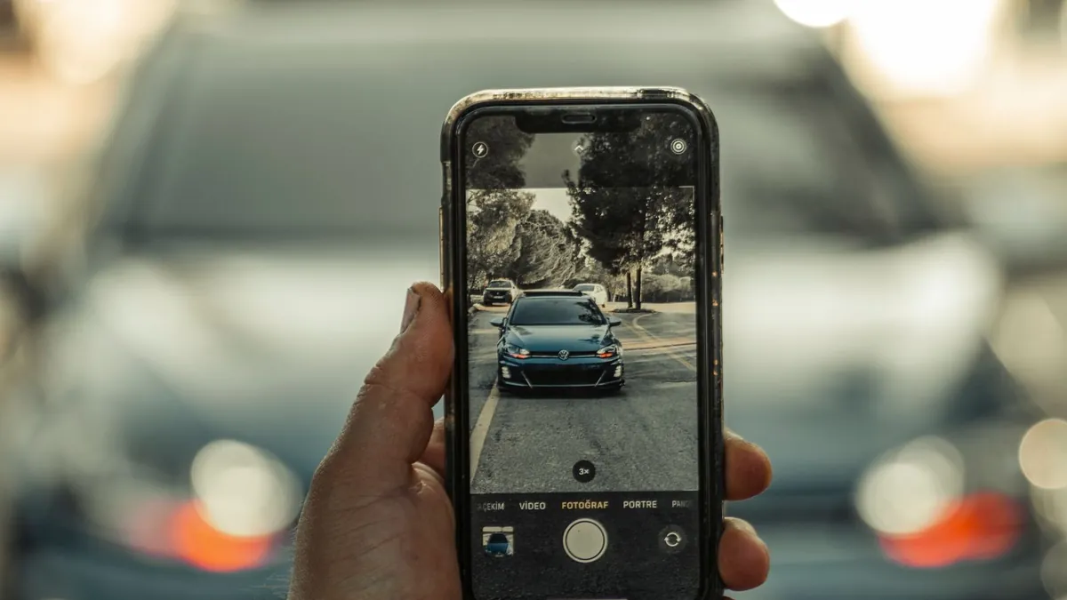 A buyer photographing a parked car with their phone