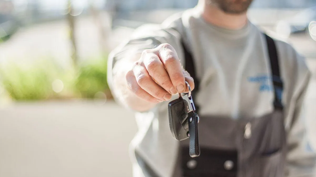 Person handing over car keys for a vehicle transaction