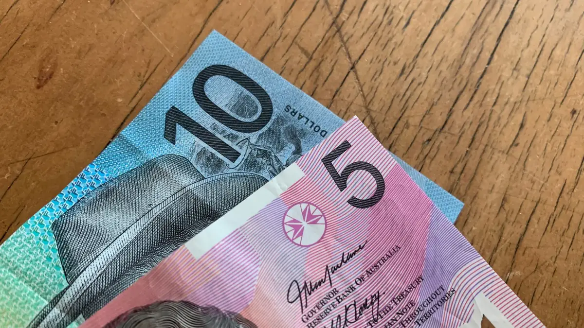 Australian ten and five dollar notes on a wooden table